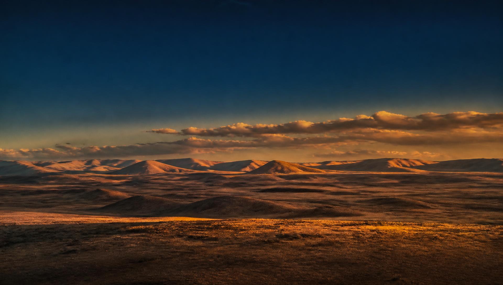 Open American plains meeting a wide horizon at golden hour